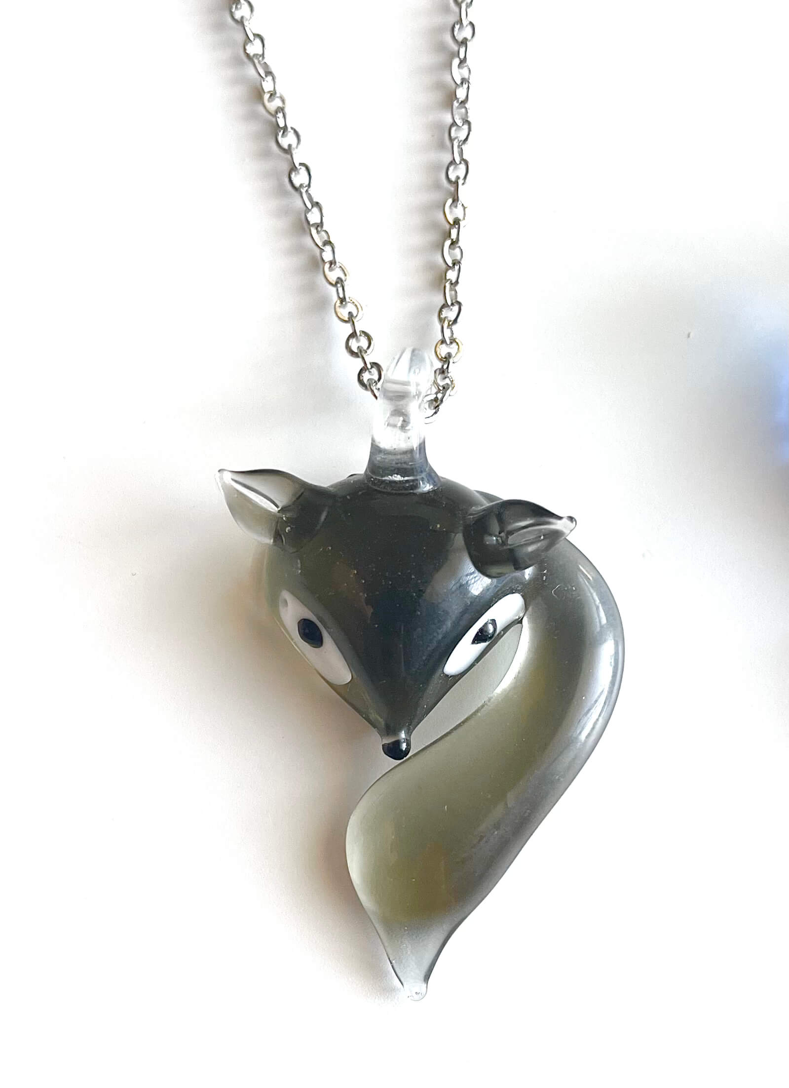 Fox-shaped pendant on a chain against a white background