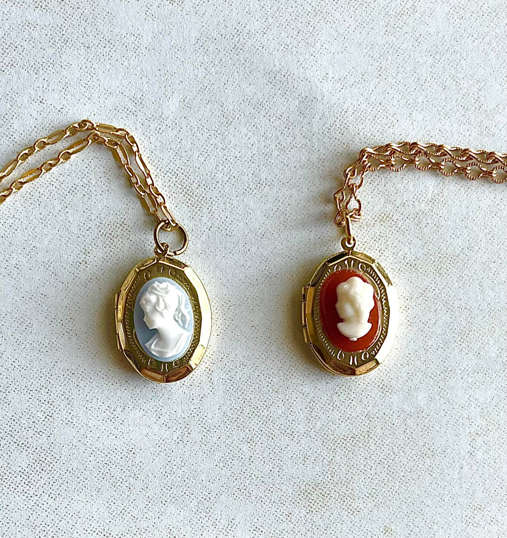 Yellow brass locket necklaces with white and blue/white and red cameos on fancy chains. 