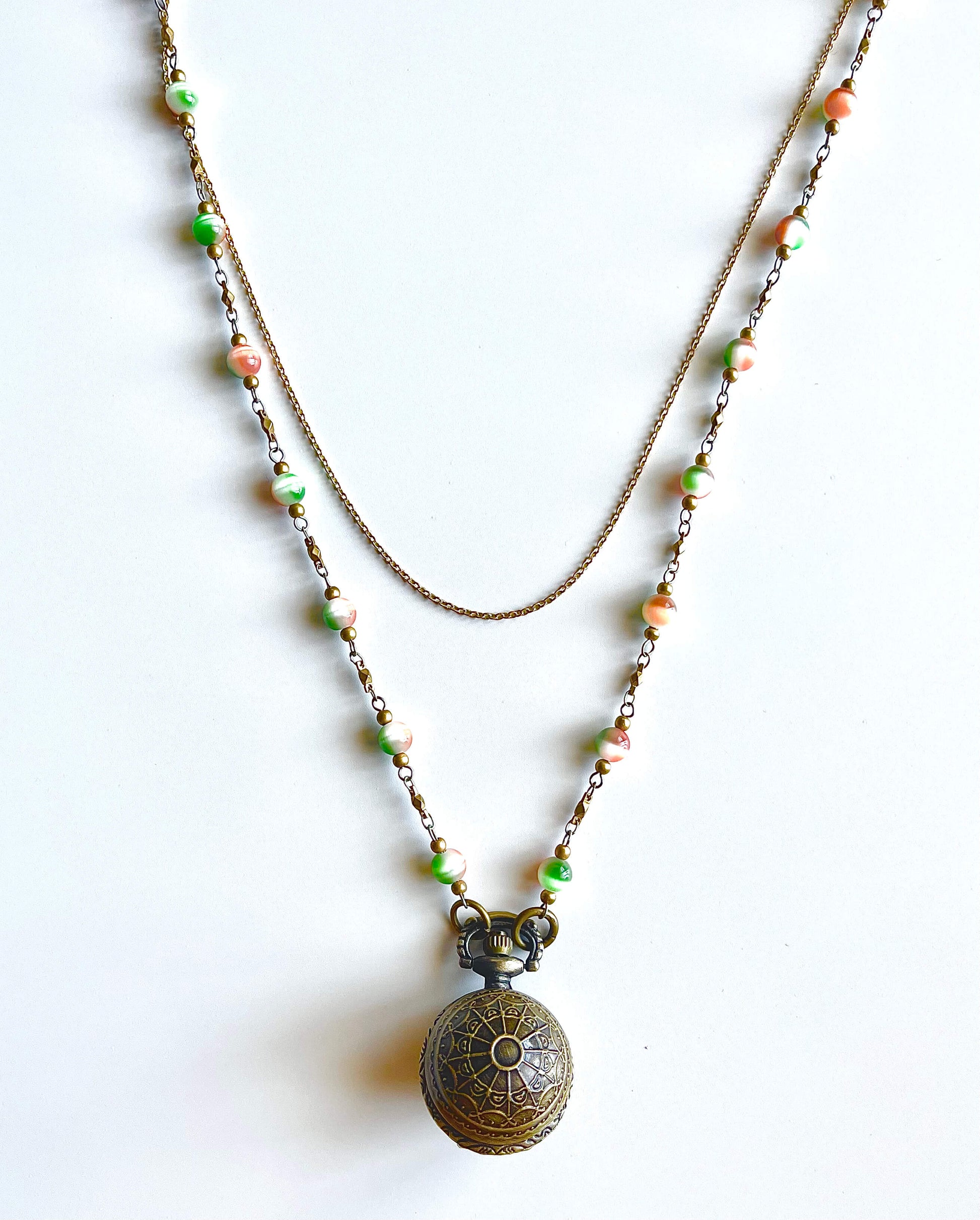 Round Locket pendant on green and orange bead chain with white background