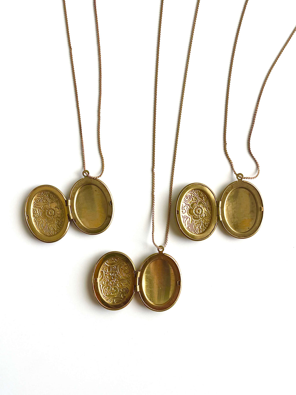 Multiple yellow brass lockets open on a white background