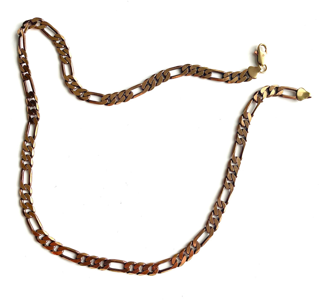 Yellow brass Figaro chain necklace with lobster clasp on a white backdrop
