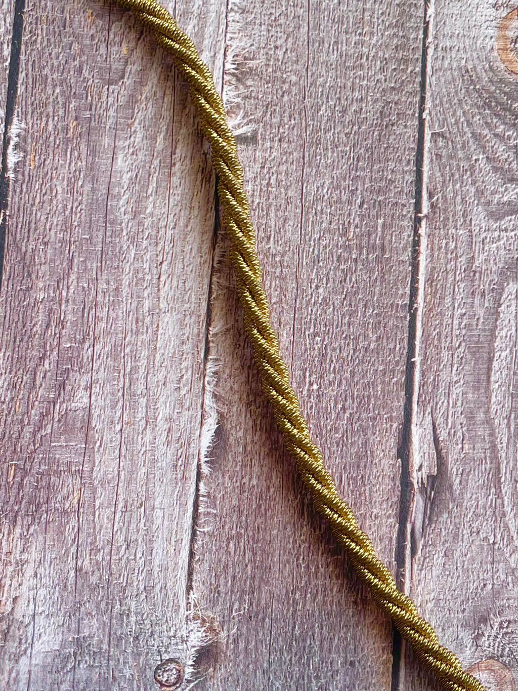 Yellow brass twisted mesh rope choker necklace on a wood background
