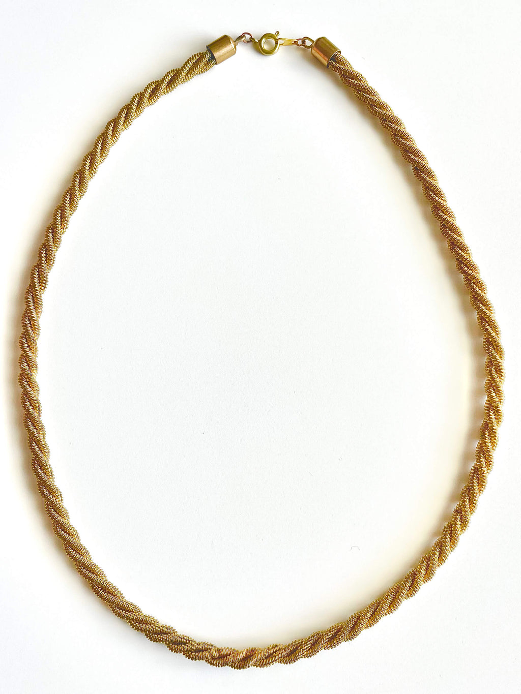 Yellow brass twisted mesh rope necklace on white background