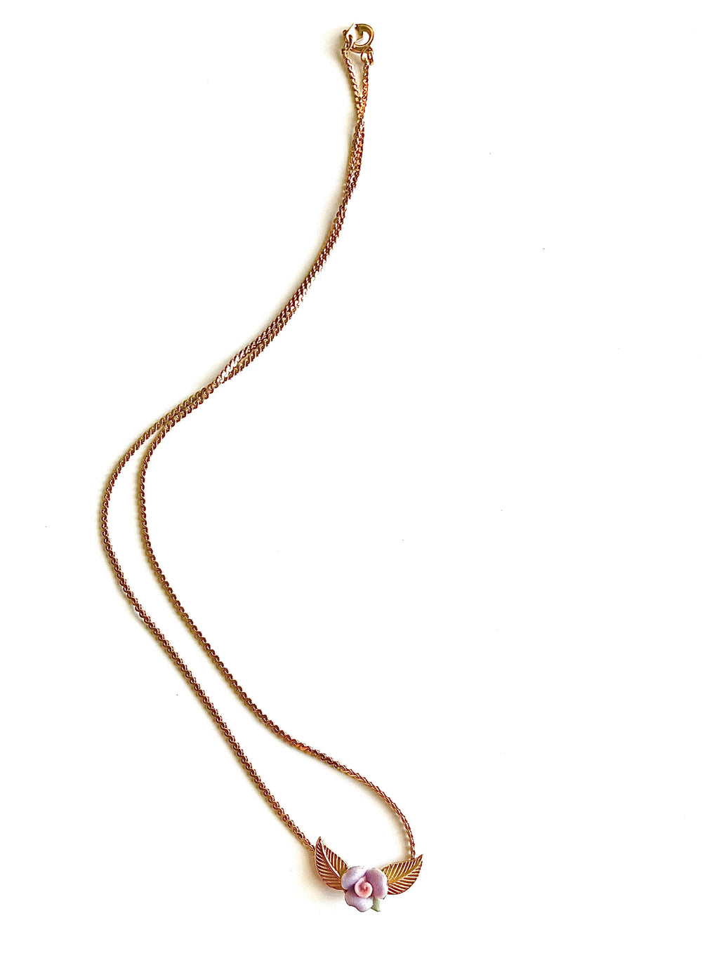 Yellow brass necklace with purple and pink clay flower on a white background