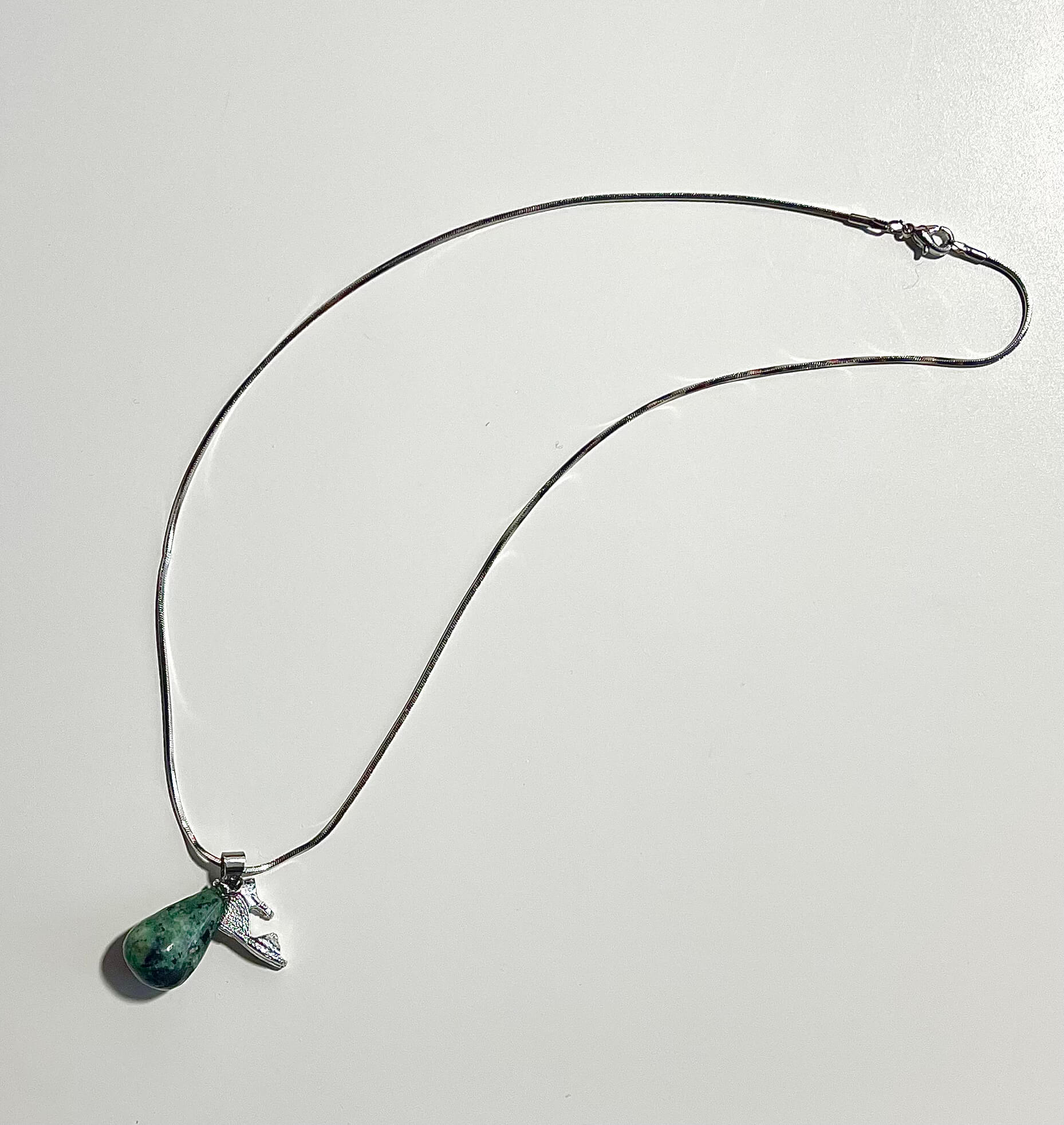 Silver necklace with shoe charm and teardrop zoisite with white backdrop